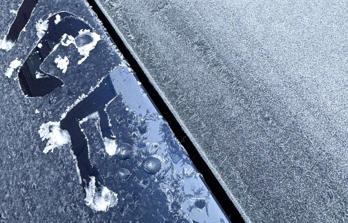 Frostiga stenplattor med en figur ritad i frosten bredvid en mörk fog